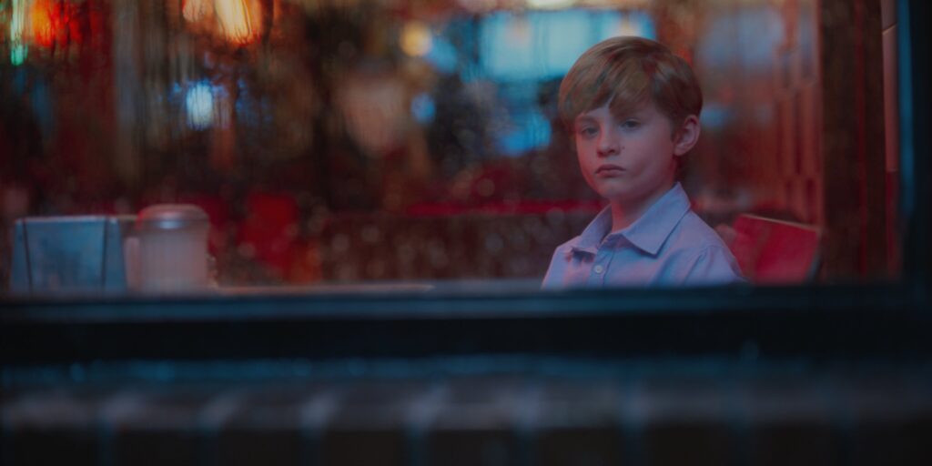 Austin Schoenfeld looking through rainy window at restaurant
