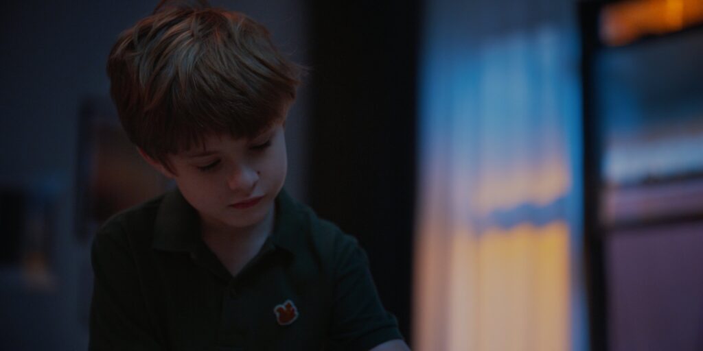 Boy looking down in dramatic magic hour lighting