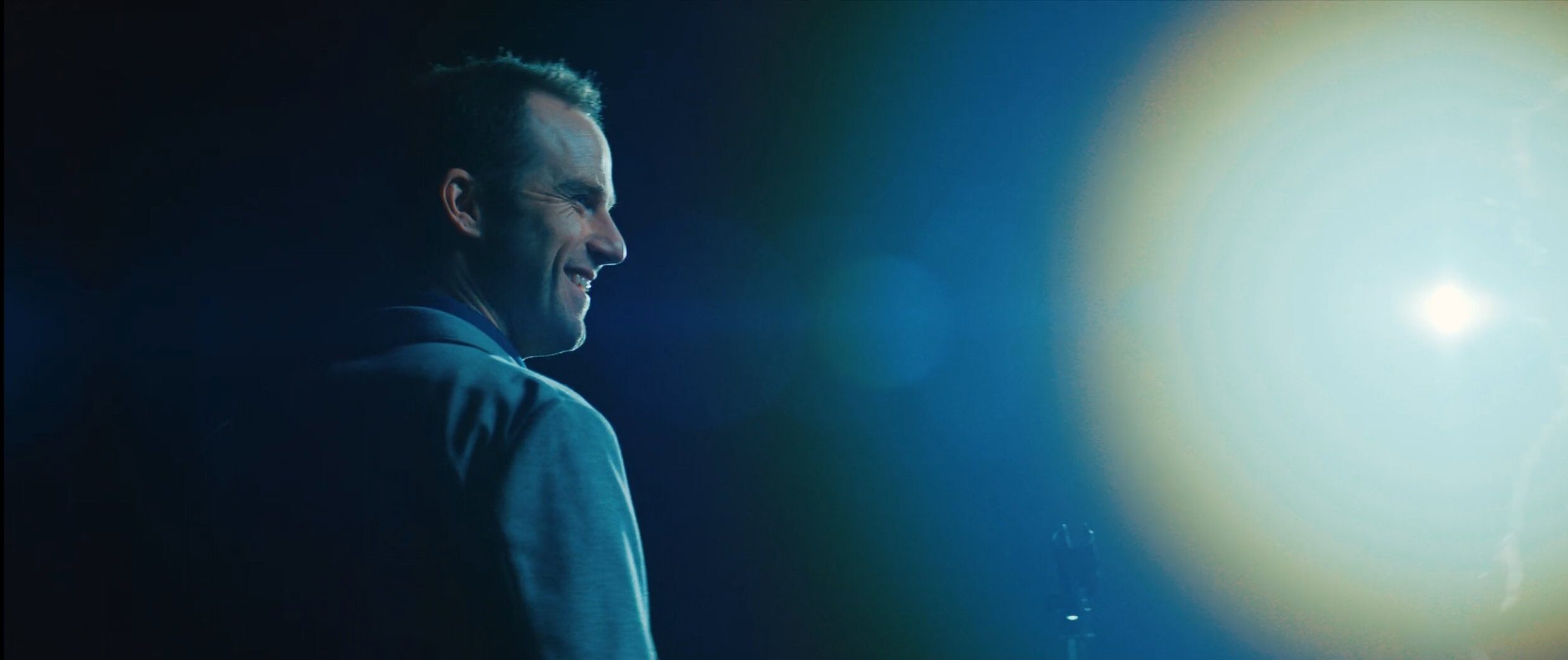 Man looking over his shoulder in dramatic lighting with anamorphic flares