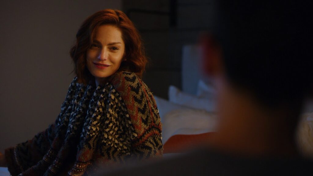 Close up of a Diana Gettinger sitting on a bed and smiling at someone