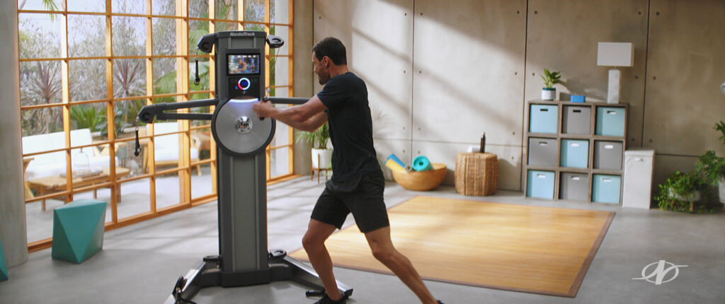 Athletic man using fitness machine in personal gym - tv commercial