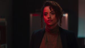 Close up of Nicole Castillo-Mavromatis lit in red and orange warm lighting