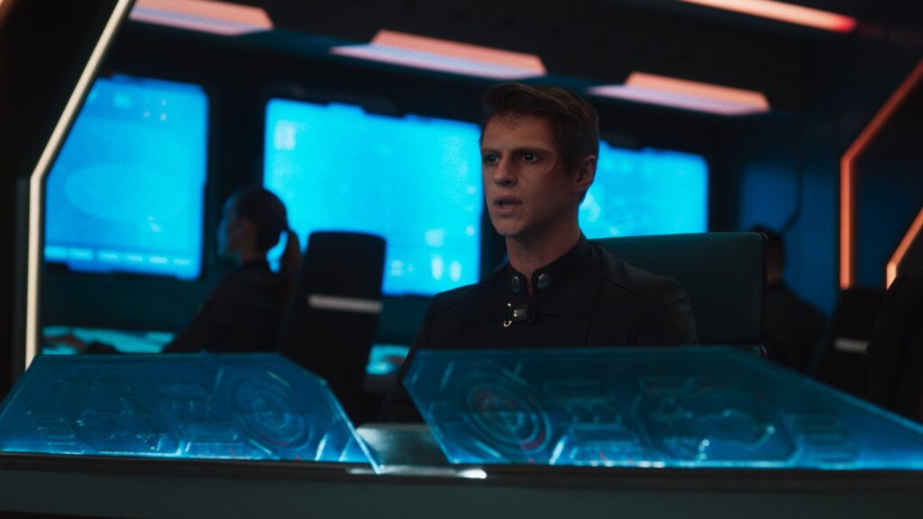 Spaceship command deck with alien character Ben Radcliffe in cyan blue lighting