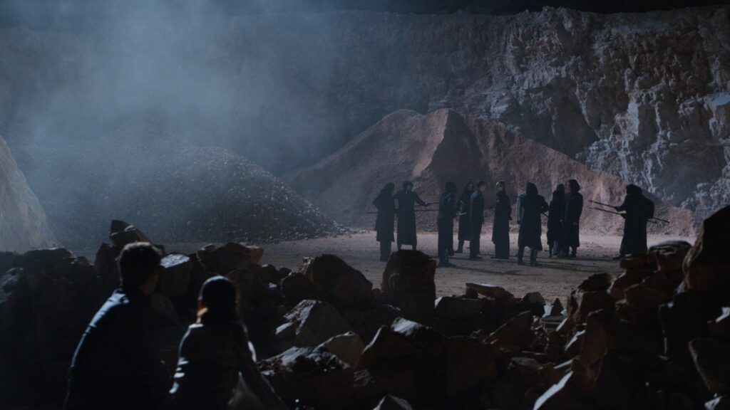 Two people observing mysterious scene at a quarry at night