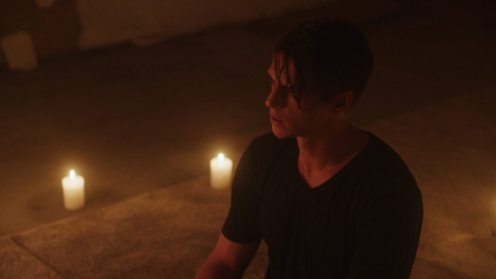 Candle lit scene with person sitting on floor