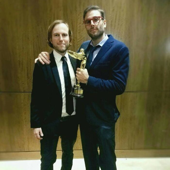 Maximilian Schmige and Adam Cosco holding award trophy