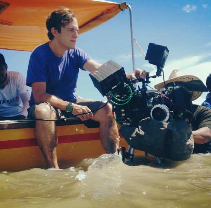 Cinematographer Maximilian Schmige filming a scene from a boat in Malaysia