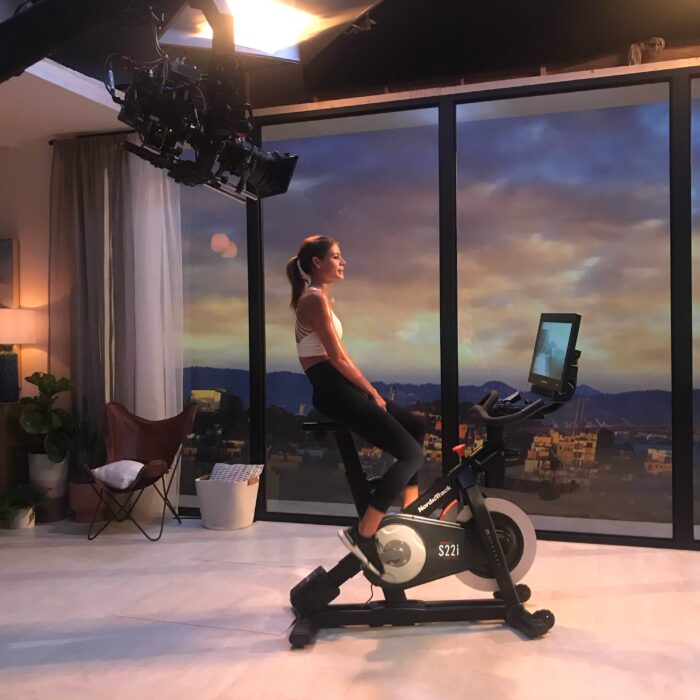 woman on nordictrack bicycle filmed by camera on a jib in living room set