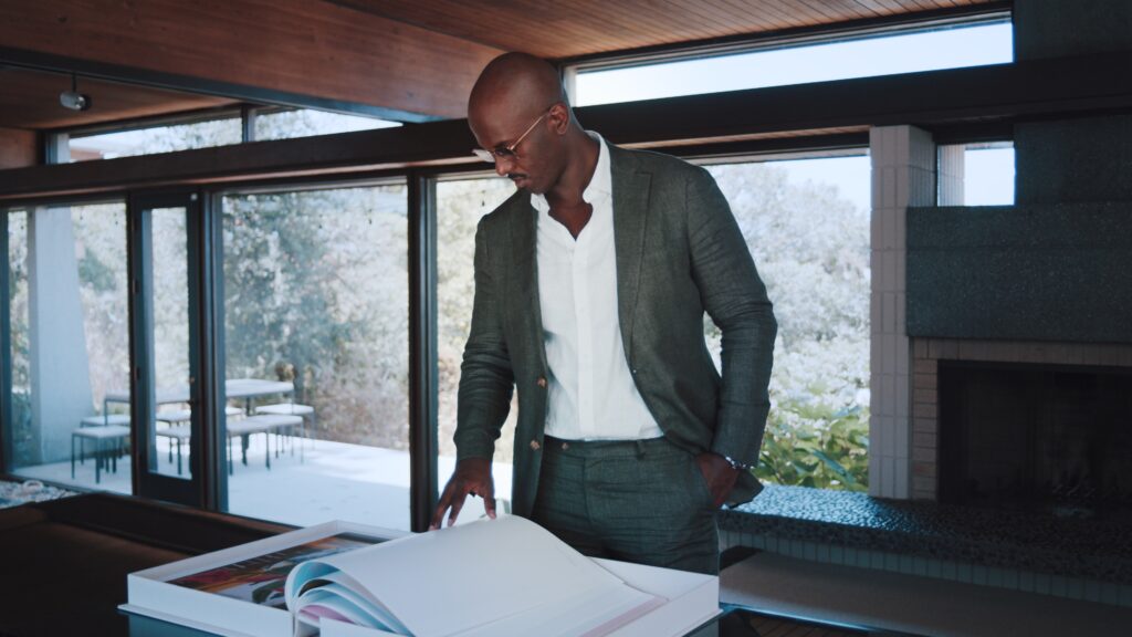 Man in suit looking at large book in modern living room