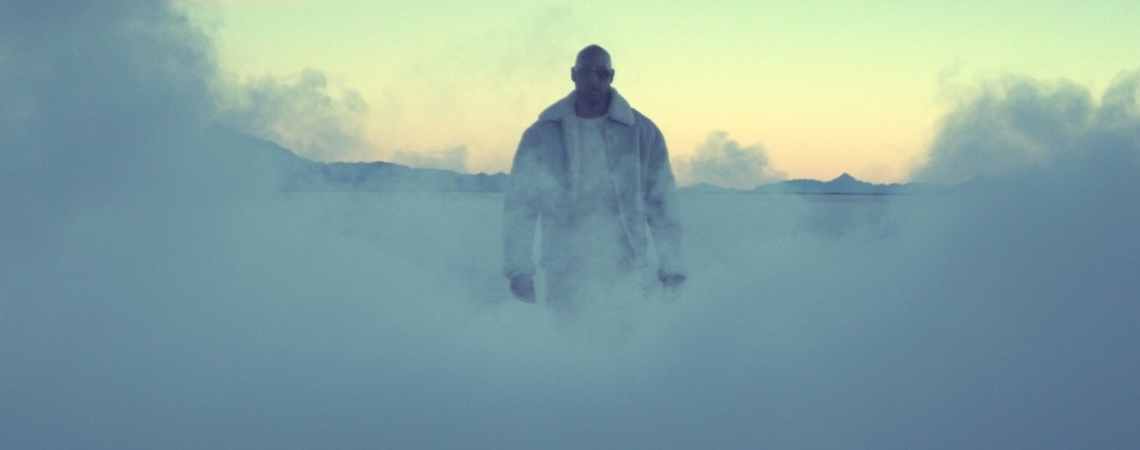 Man walking thtrough thick smoke at magic hour