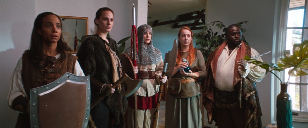 Four medival characters in modern living room holding swords and shields