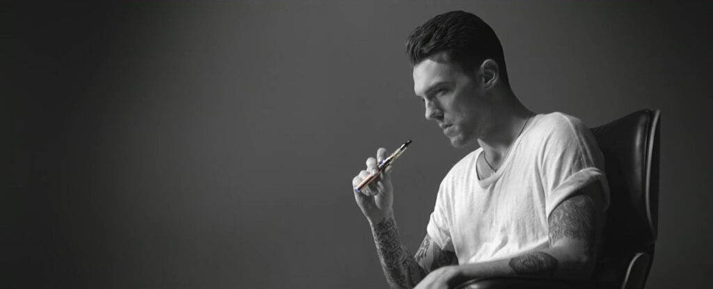 Man holding a vape in dramatic studio lighting setting