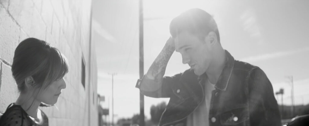 Man modelling to woman on street with strong lens flares