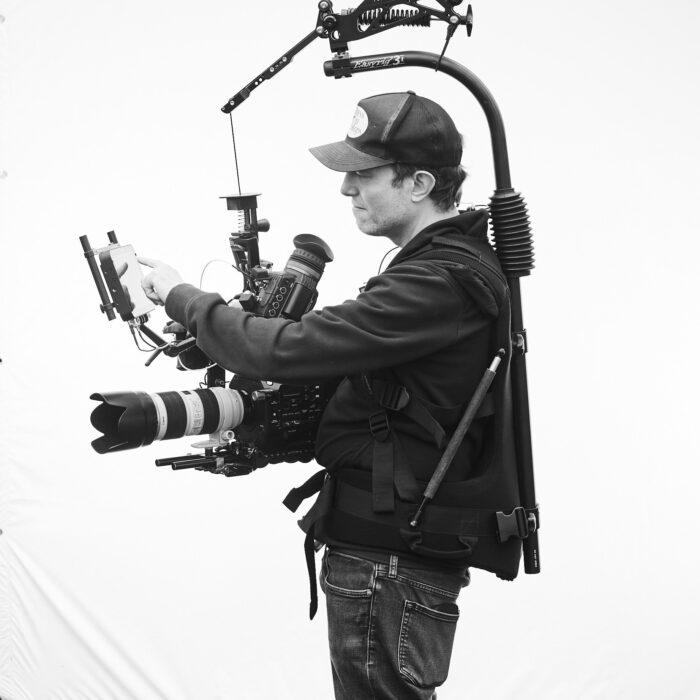 Maximilian Schmige wearing an easyrig and adjusting settings on a sony camera set up