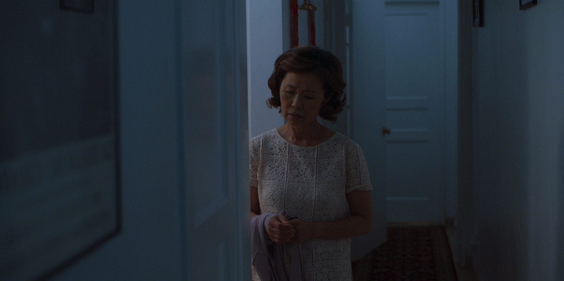 Woman standing in dark corridor contemplating