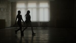 Silhouette of two people walking through hallway