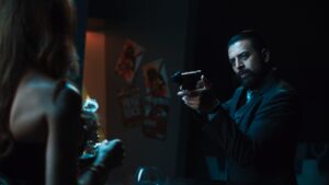 Actor Vikash Bhai pointing gun at another person in dimly lit scene