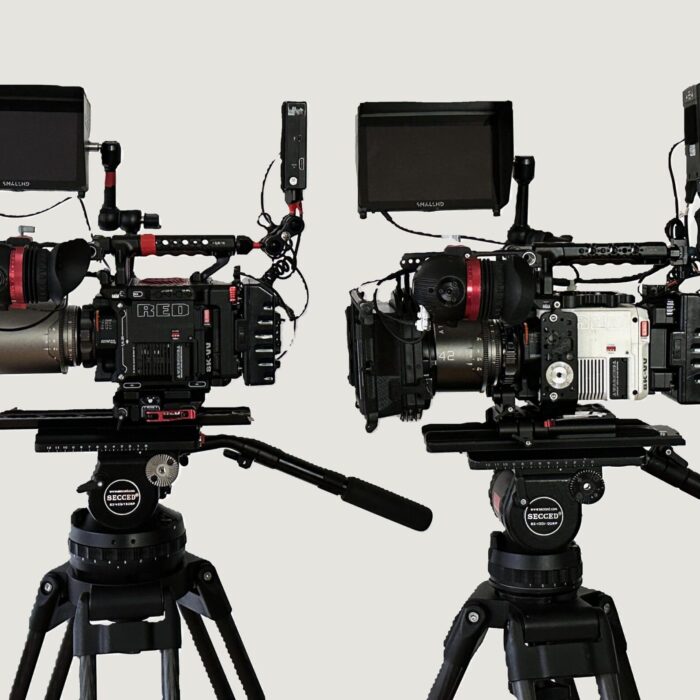 two red v-raptor cameras with atlas mercury anamorphic lenses, secced tripod, zacuto gratical eye viewfinders, against white backdrop