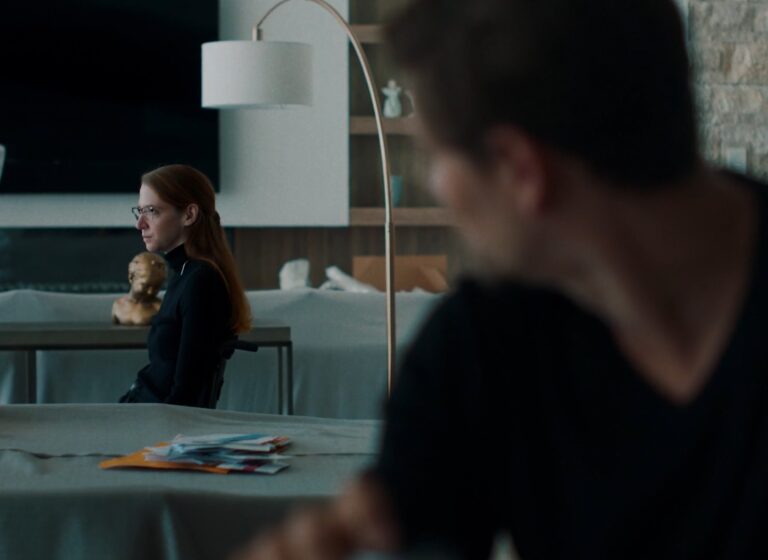 Over the shoulder shot looking at Cary Cox in wheelchair looking out the window