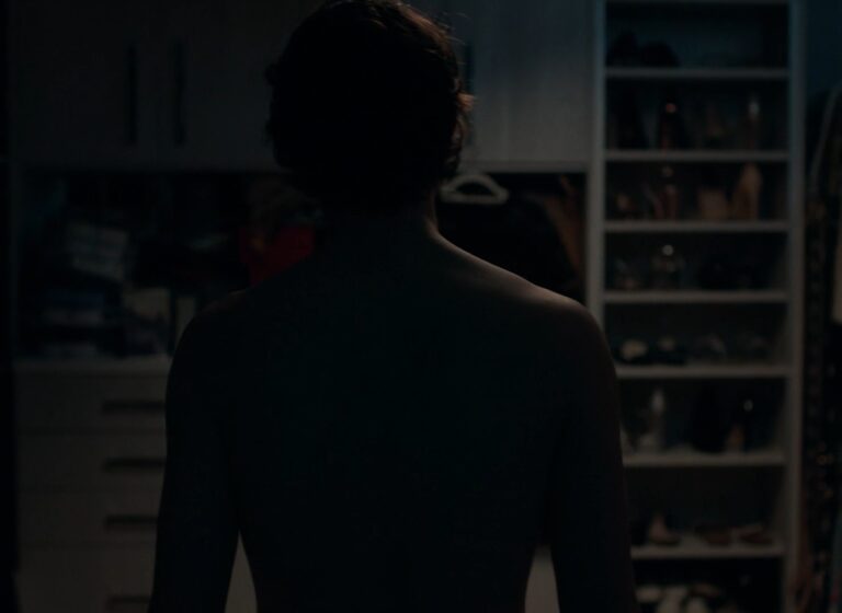 Dramatic silhouette shot of a man walking into a walking closet at night