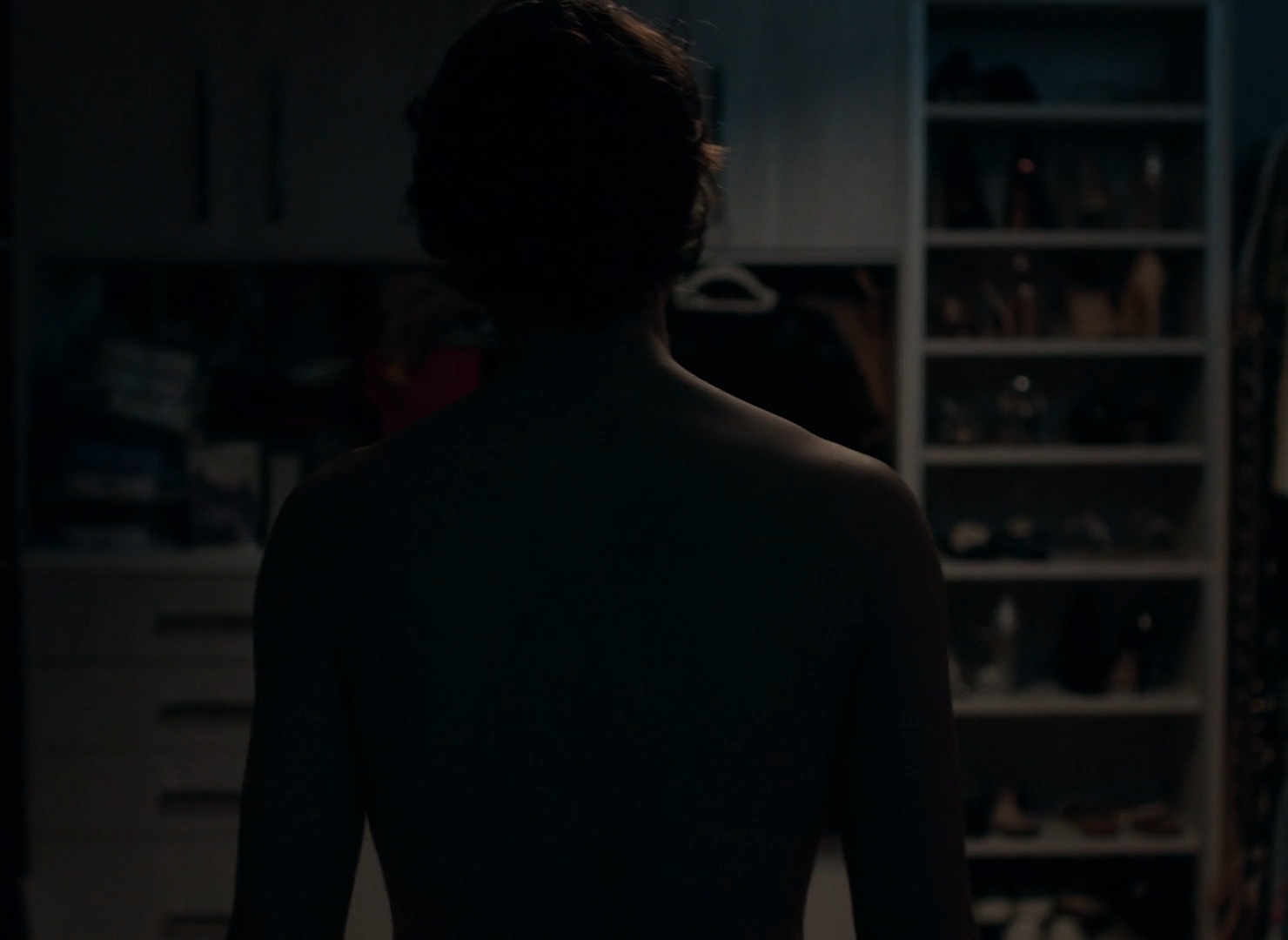 Dramatic silhouette shot of a man walking into a walking closet at night