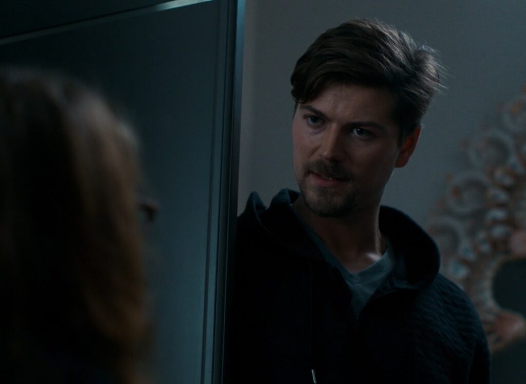 Dramatic close up shot of Amadeus Serafini standing in doorway