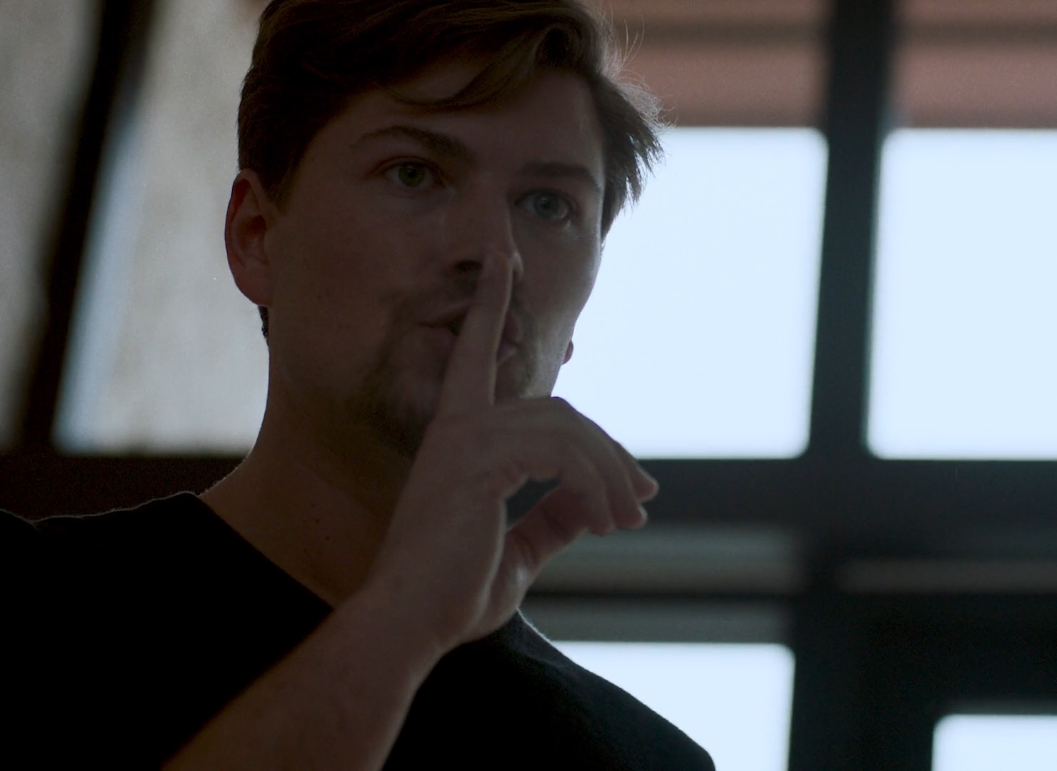 Amadeus Serafini with index finger at mouth asking for silence