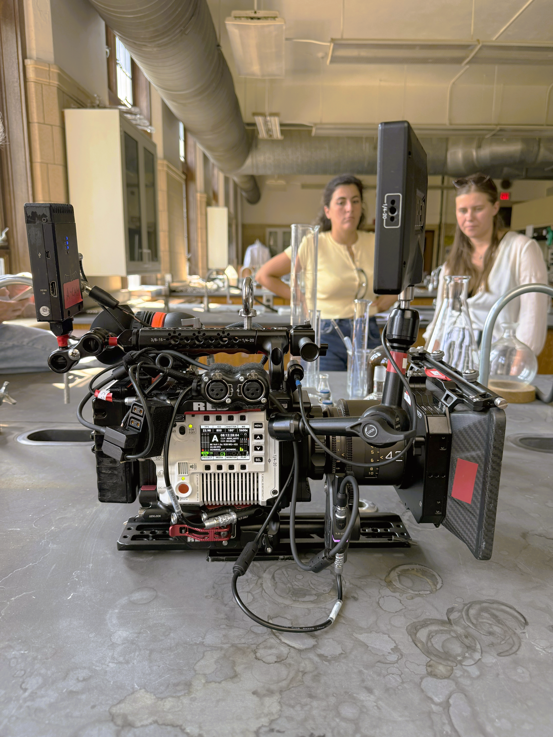 red raptor white stormtrooper camera with atlas mercury on a counter. two women in the background
