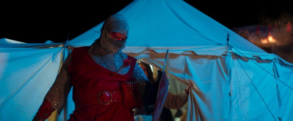 Man in middle ages knight outfit getting shot by an arrow