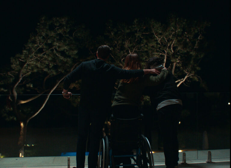 Group of friends looking out at trees at night