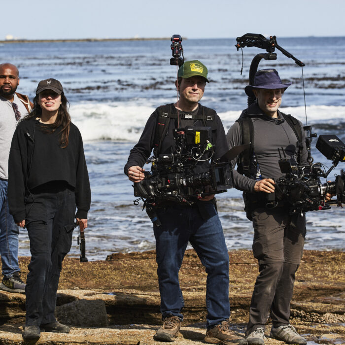 Maximilian Schmige in the middle next to Dustin Pearlam holding cameras with easyrigs by the coast line