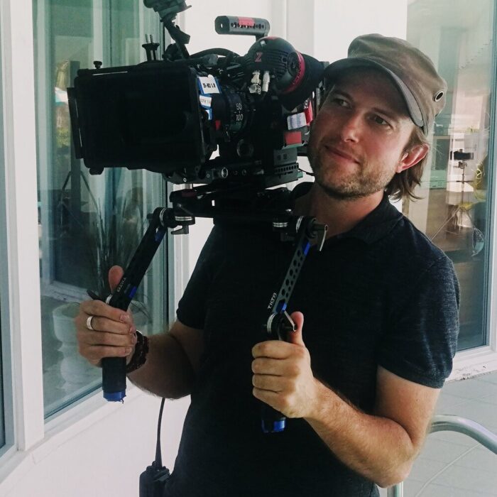 Cinematographer Maximilian Schmige hand holding cinema camera wit lens on movie set