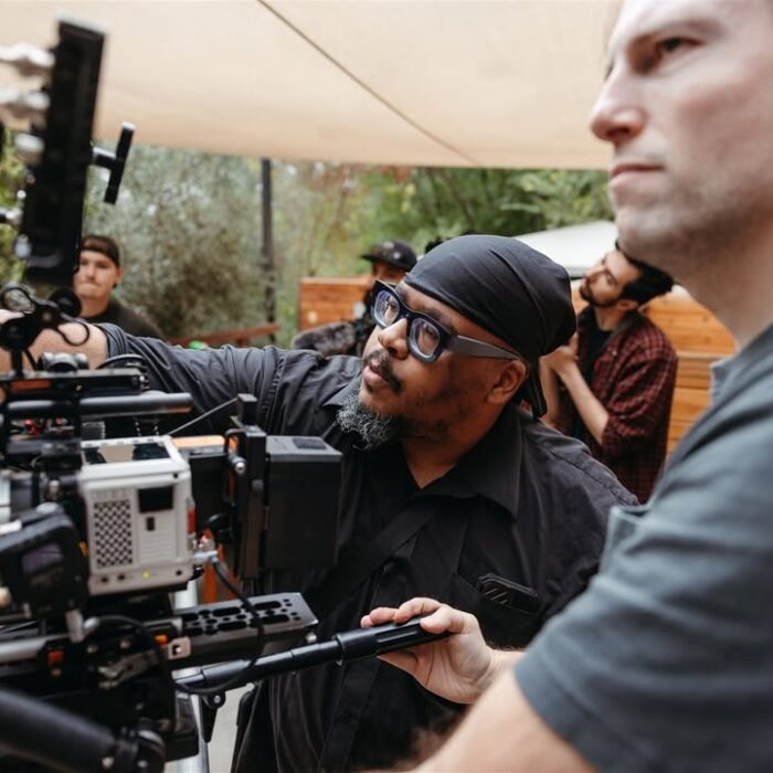 Maximilian Schmige and director Gregg Payton on set with Red Komodo camera pointing in the director of the lens