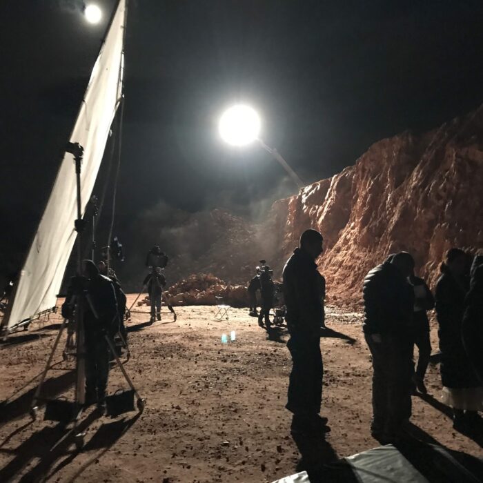 Exterior night film set with large condor light with light and bounce frame in a quarry at night