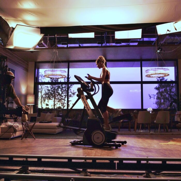 Film studio set up with motion control camera rig on tracks and soft box lighting in living room set