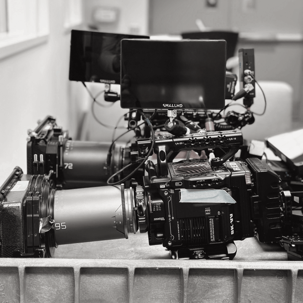 Two RED V-Raptor cinema camaras with Atlas Mercury Anamorphic lenses are stacked side by side on a table.