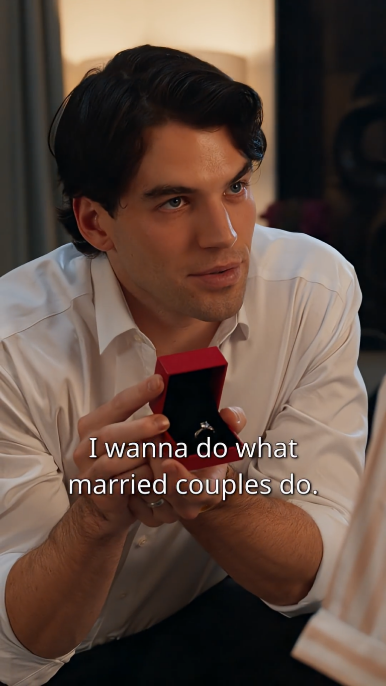 Close up of man on his knees proposing to a woman opening a box with a wedding ring inside