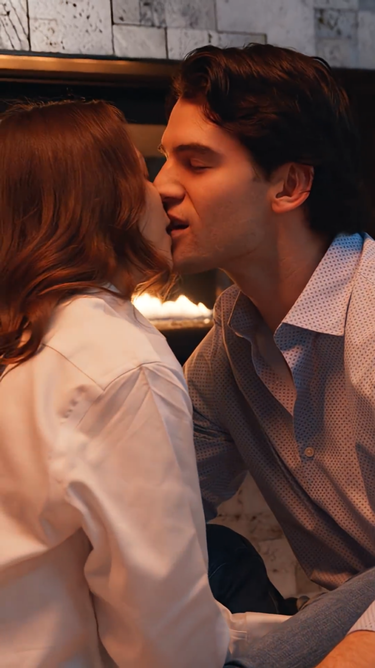 Noah Fearnley as William Gordon and Chena Verony as Pauline Stewart upfront a fireplace in warm romantic lighting