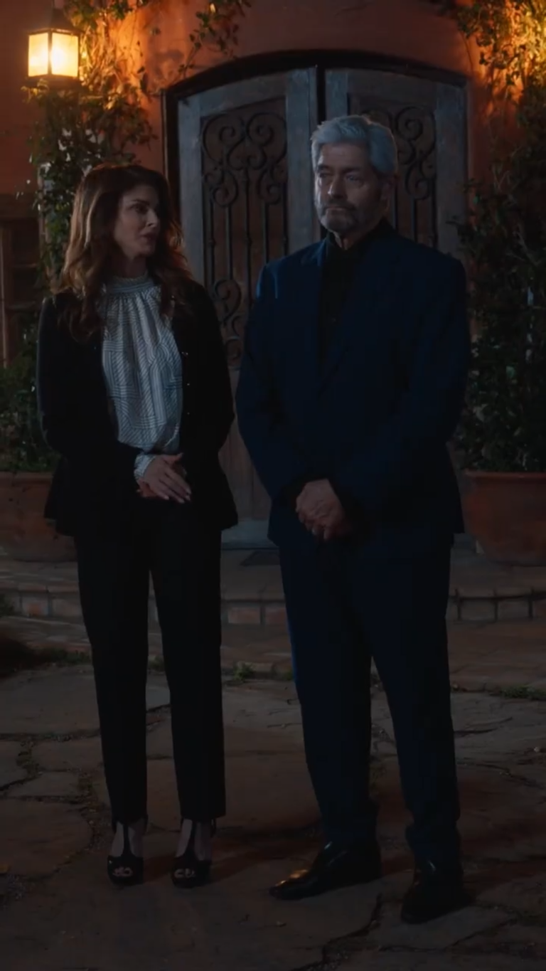 two elderly couple standing outside a house at night in moonlight