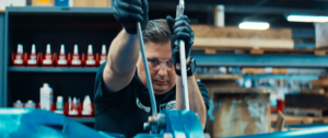 Male worker pulling on two wrenches in warehouse location