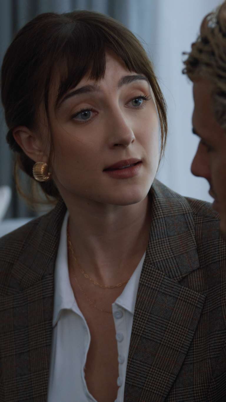Tess Dinerstein in business suit leaning over talking to a man
